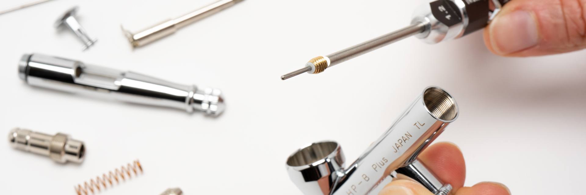 Iwata Airbrush disassembled to show packing screws